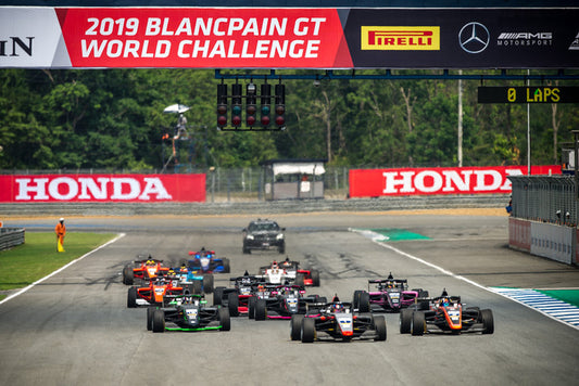 Wide shot of all cars leaving the starting grid in the first lap of the race